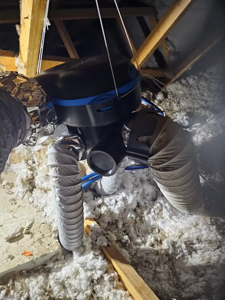 Installation d'une gaine de ventilation VMC dans l'isolation des combles