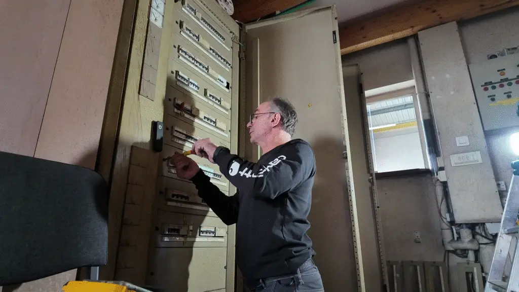 Électricien ERA Électricité intervenant sur un tableau électrique dans un local technique