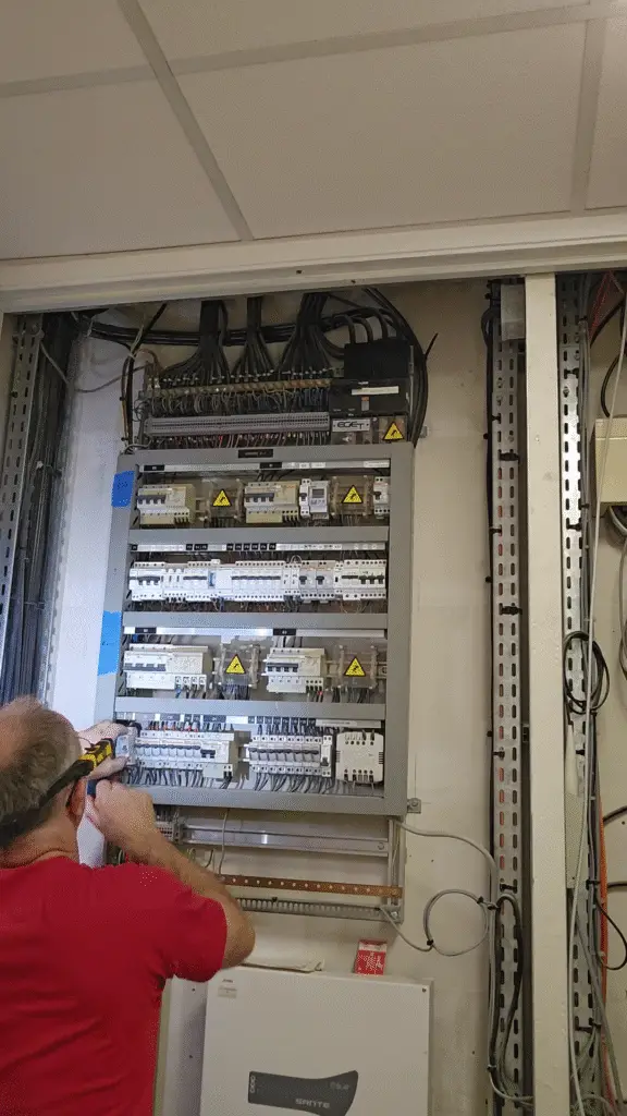 Électricien ERA câblant un tableau électrique neuf conforme aux normes en vigueur