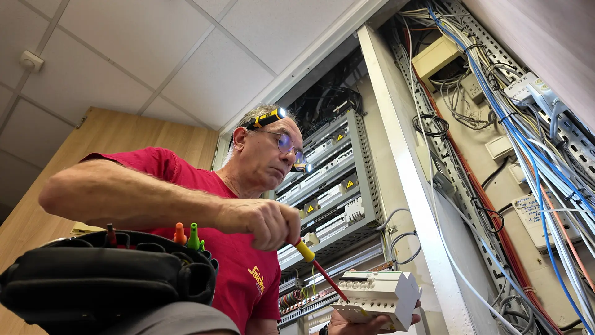 Technicien ERA Électricité réalisant une mise aux normes électriques sur un tableau