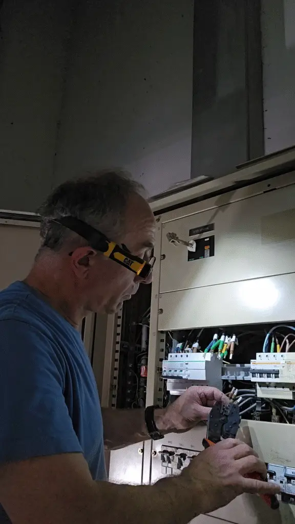 Électricien ERA réalisant le diagnostic d'un tableau électrique existant avant travaux