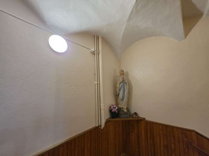 Statue de la Vierge Marie dans un couloir vouté